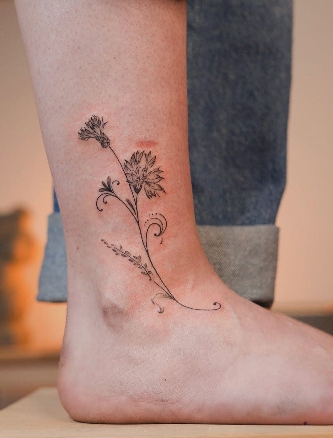 Tatuaj fineline cu flori de câmp pe gleznă
